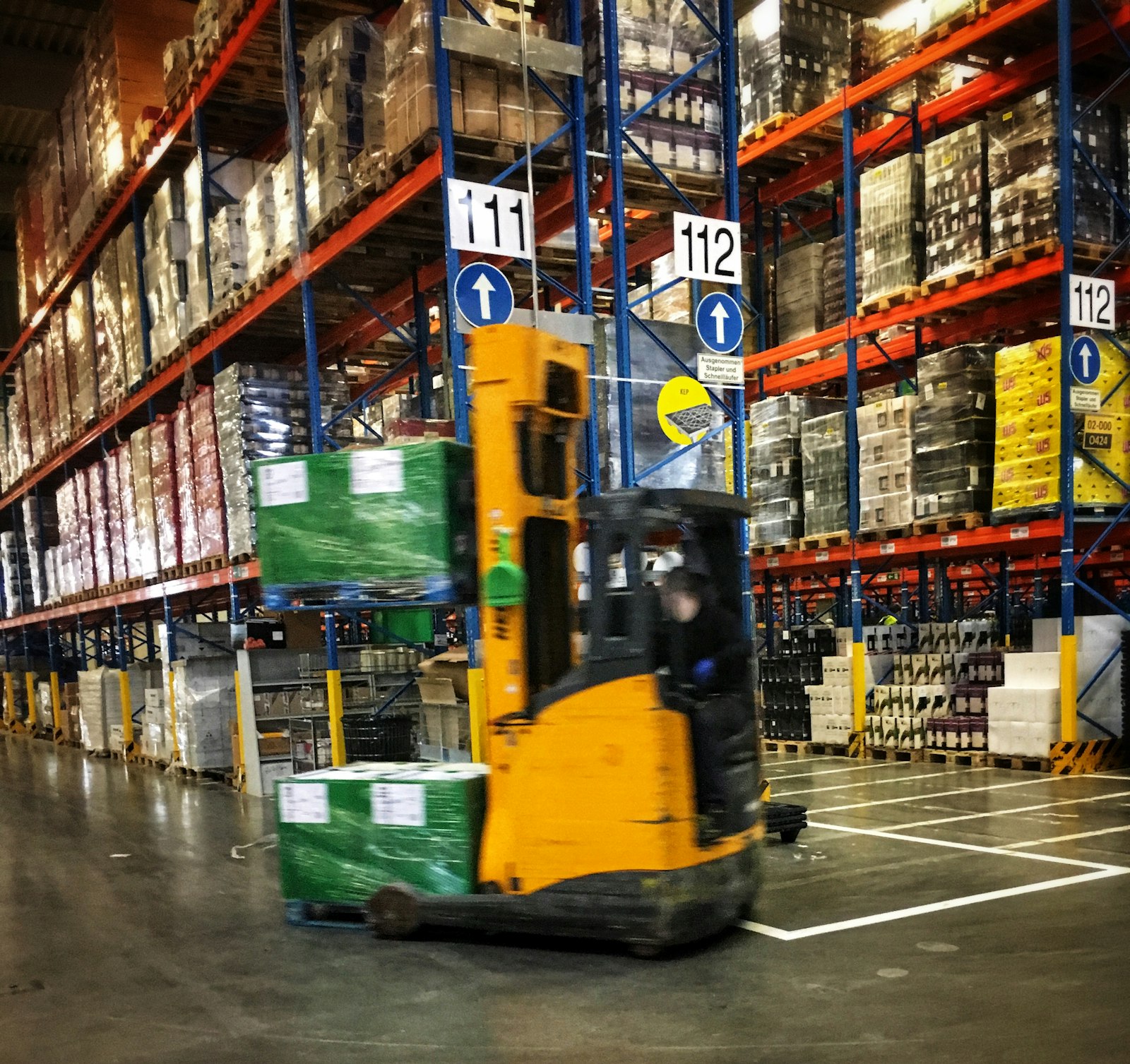 A forklift moving pallets through a distribution warehouse
